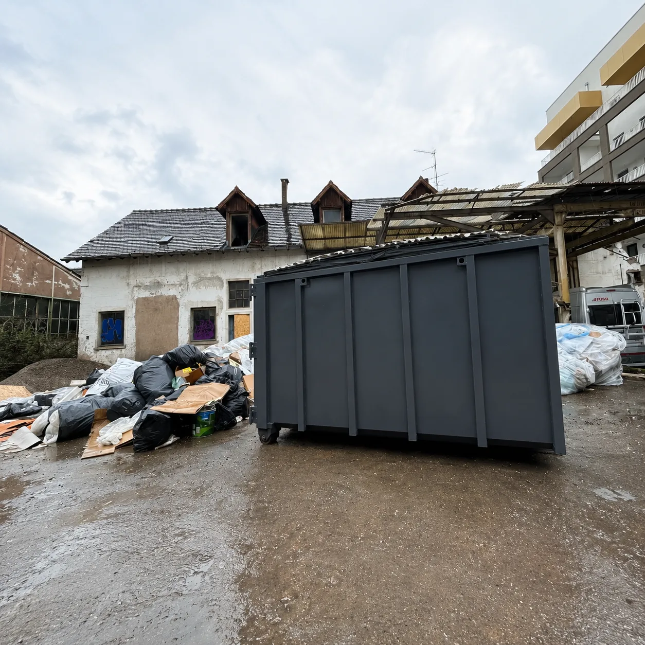 Benne pleine dans une cour, prête à être enlevée vers le centre de tri près de Colmar